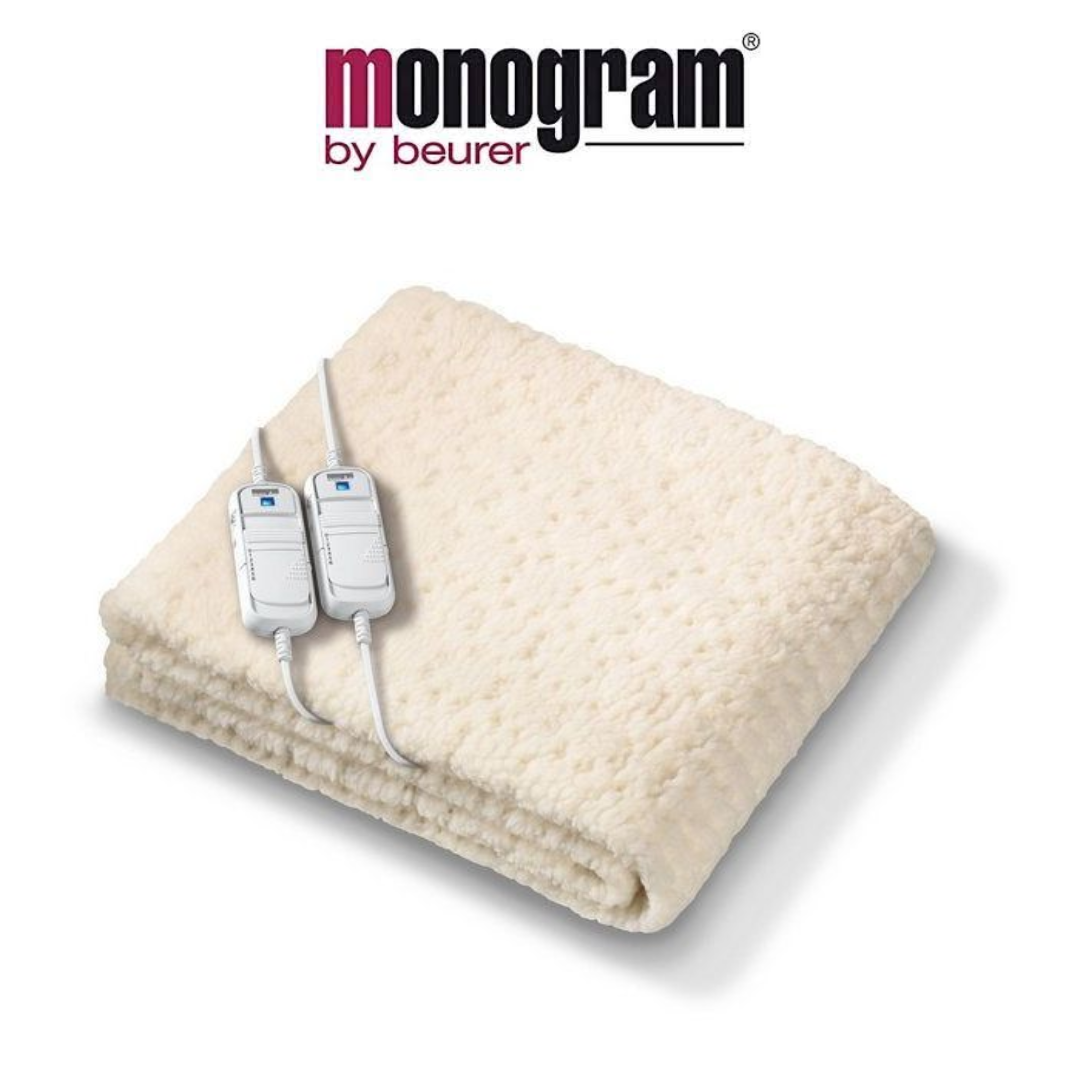 Monogram by Beurer cream-coloured heated blanket with a textured surface and two attached controllers for personalised heat settings.