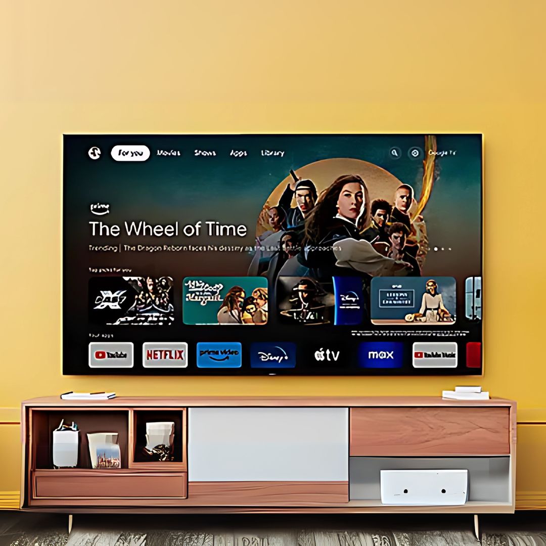  A modern Sony TV mounted on a yellow wall displaying a streaming interface with "The Wheel of Time" highlighted. Below the TV is a stylish wooden entertainment unit with decorative items and storage